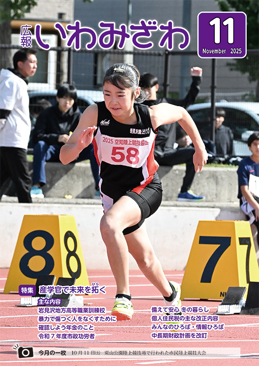 2025年10月11日(土曜日)、東山公園陸上競技場で行われた市民陸上競技大会で女子選手が前傾姿勢で走っている写真の広報いわみざわ2025年11月号表紙
