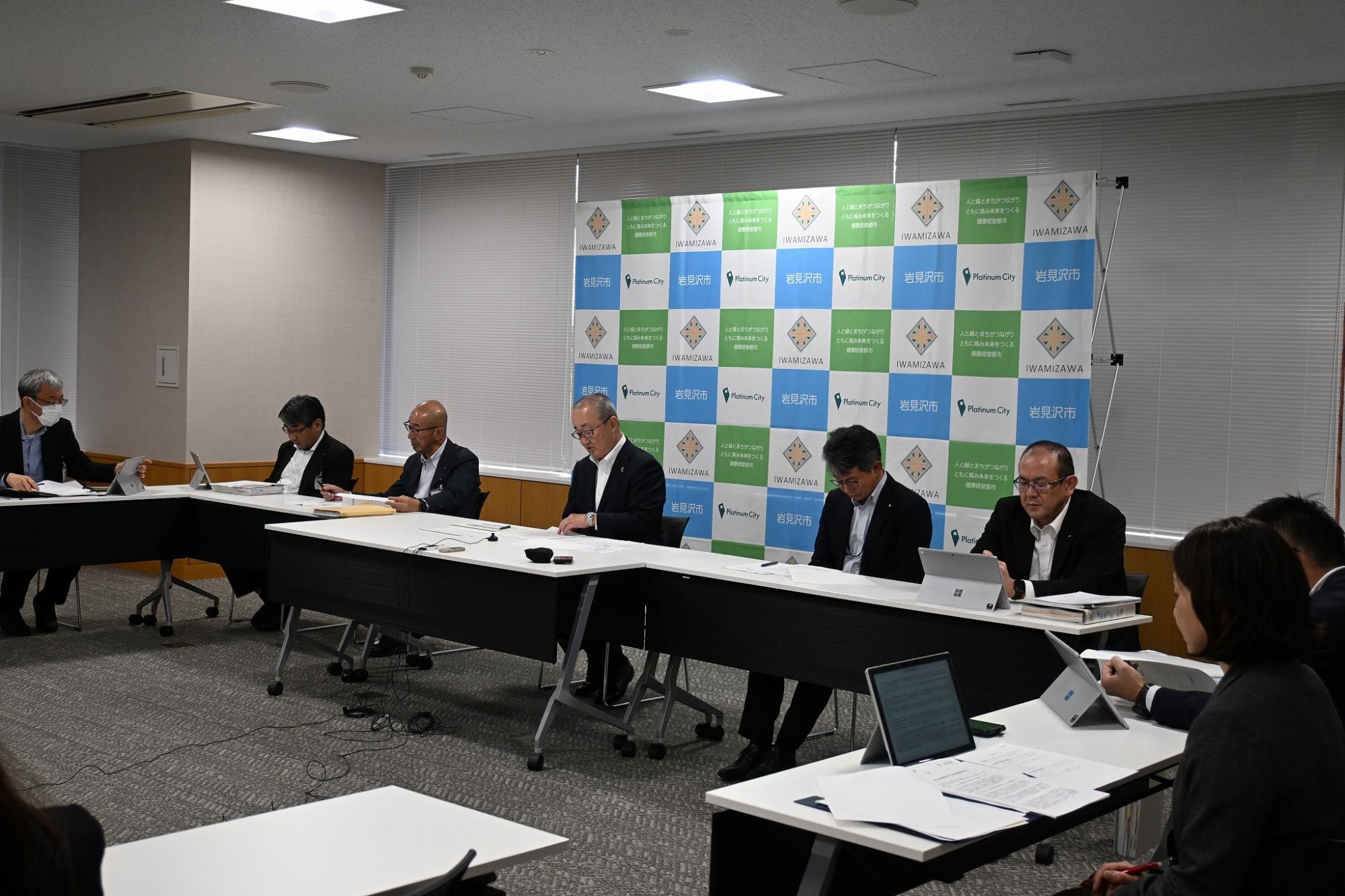 市長はじめ市の職員が並んで座っている記者懇談会会場の様子
