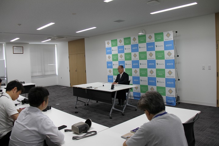 記者の質問に答える松野市長と記者会見会場全体の様子の画像