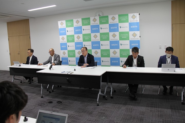 市長の他、副市長や関係部長の写った記者懇談会会場全体の様子の画像