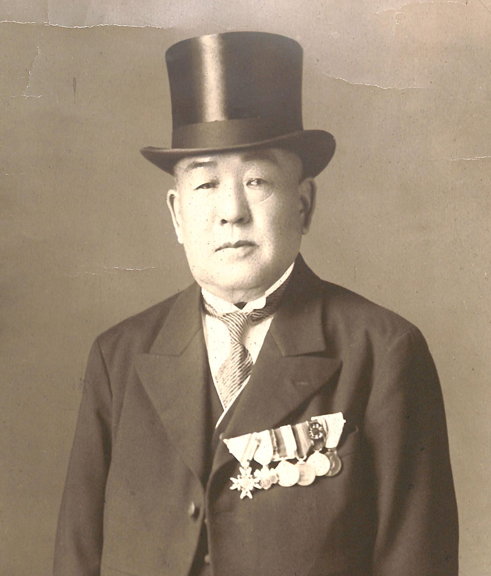 黒のシルクハットとスーツを着用し、左胸に数々の勲章をつけている高柳廣蔵のモノクロ写真