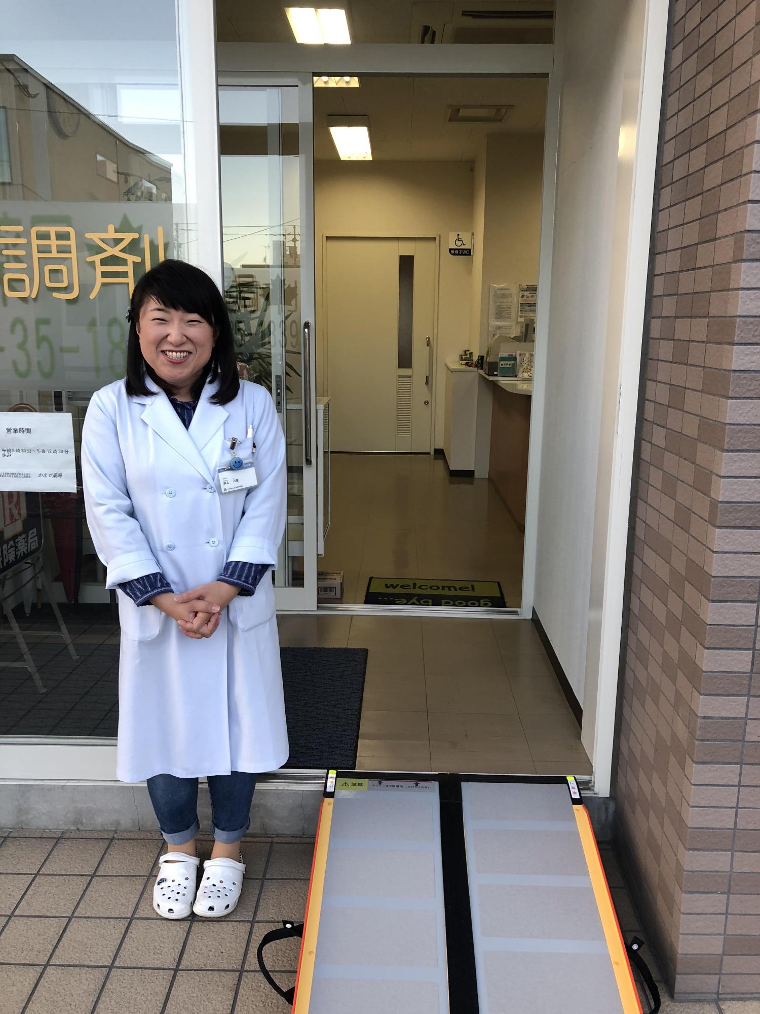 設置されたスロープの横でほほ笑む女性の写真