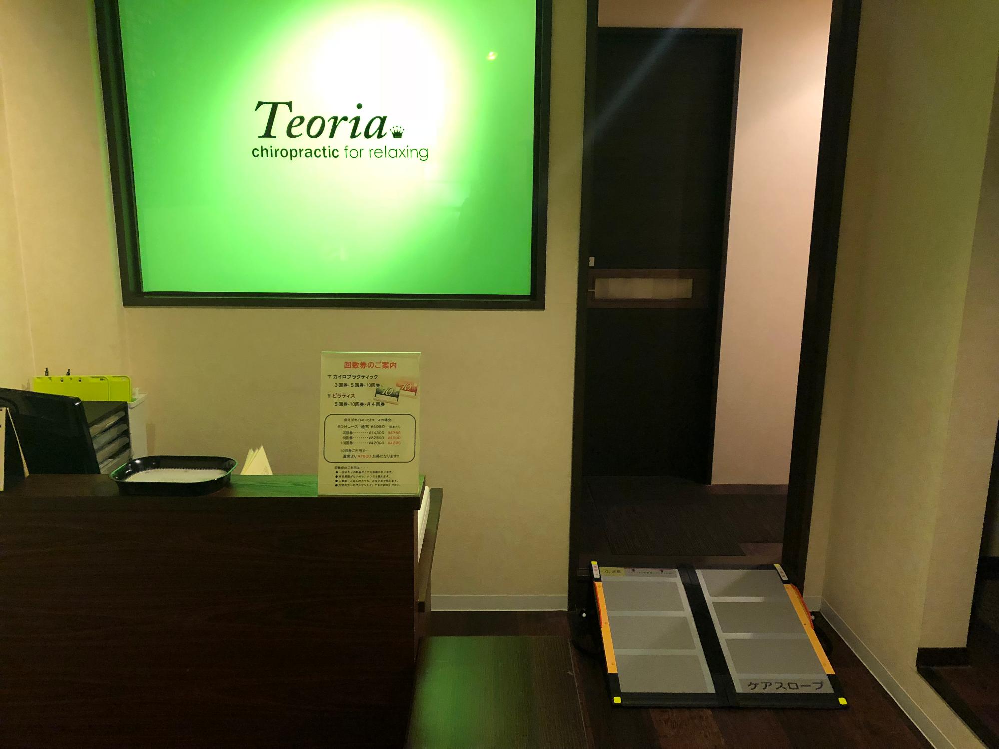 「テオリア」と書かれたネオン看板が店内受付に飾られている写真