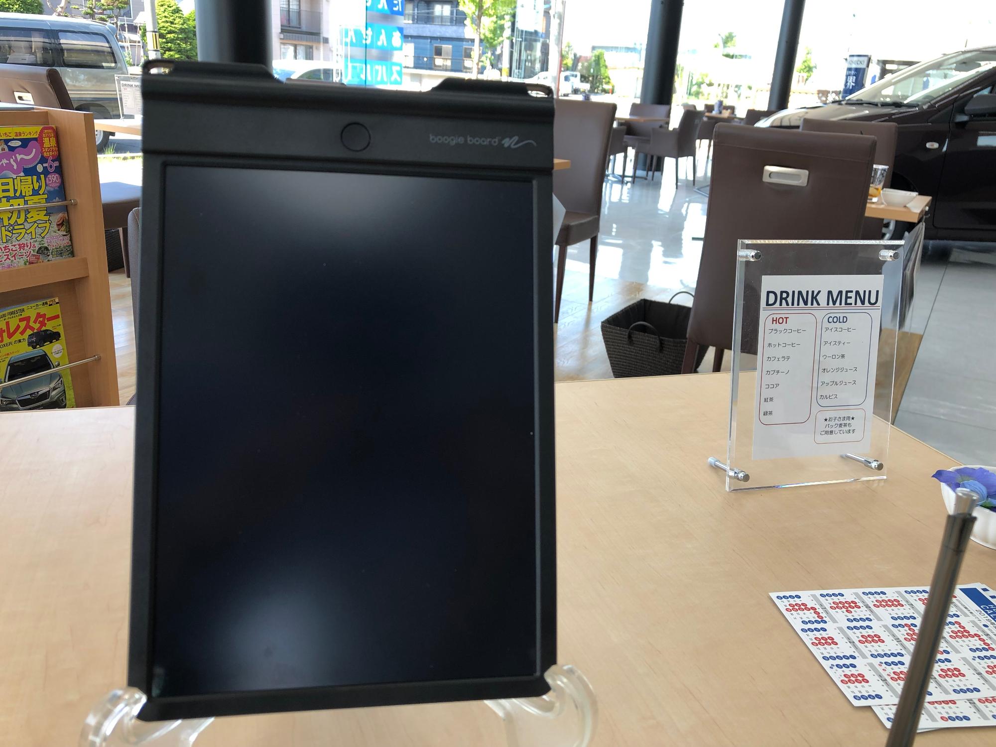 スタンドを使い机にたてられている筆談ボードの写真