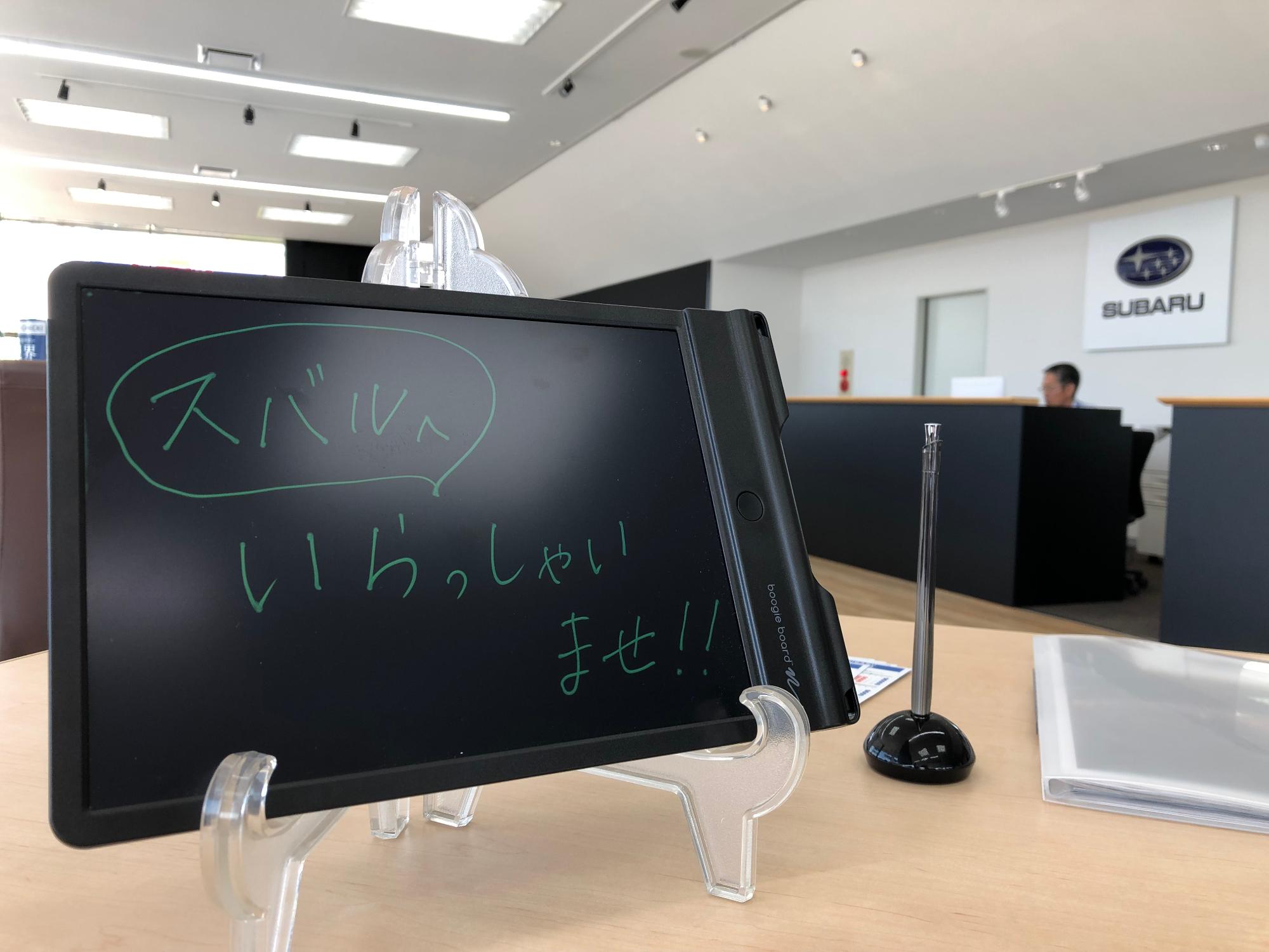 「スバルへいらっしゃいませ!」と書かれた筆談ボードが机に乗っている写真