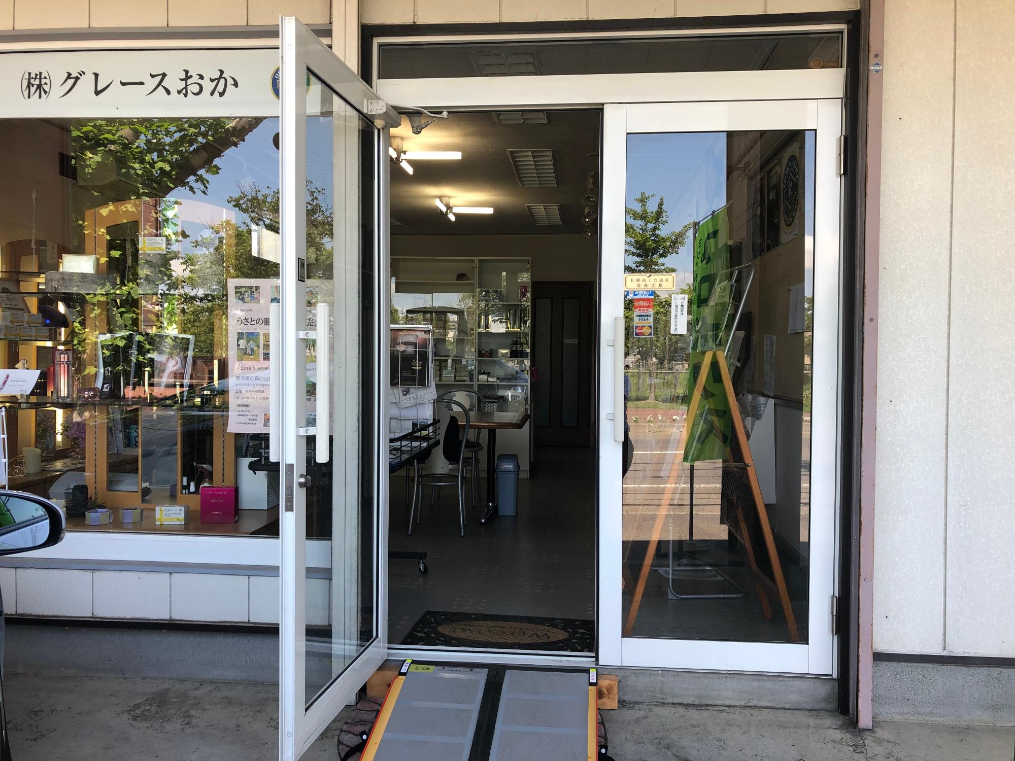 ガラス扉と全面ガラスの窓が特徴的な店内が良く見え開放的な雰囲気のグレースおか店舗外観の写真