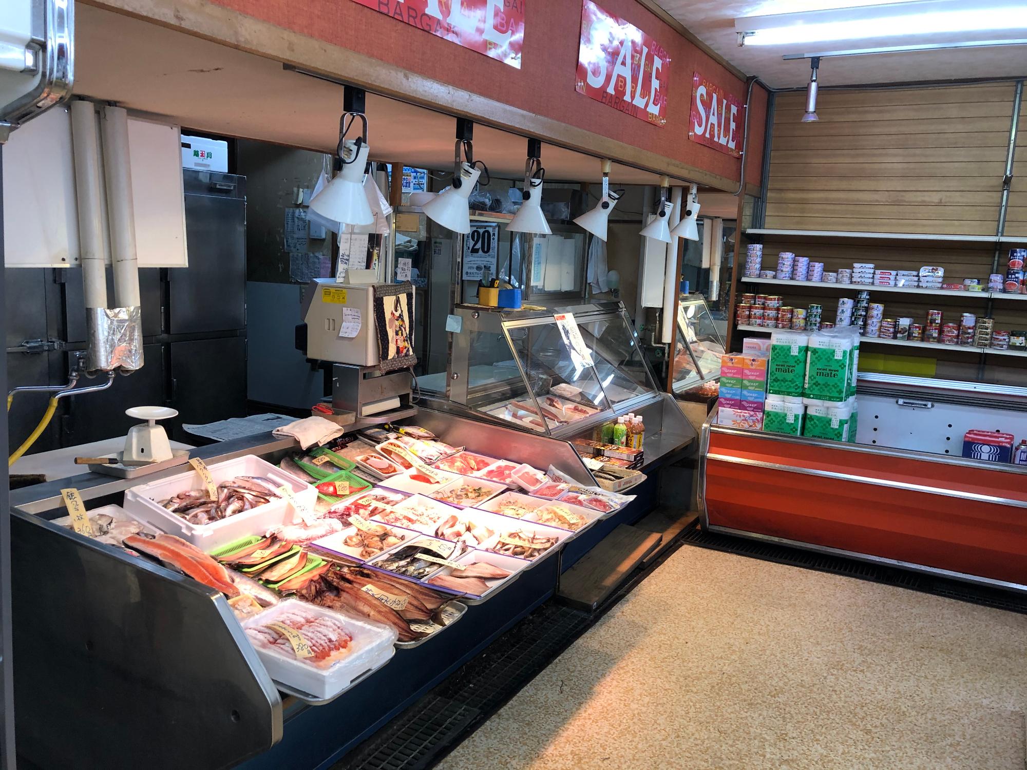 新鮮な様々な種類の魚が販売されている店舗内観の写真