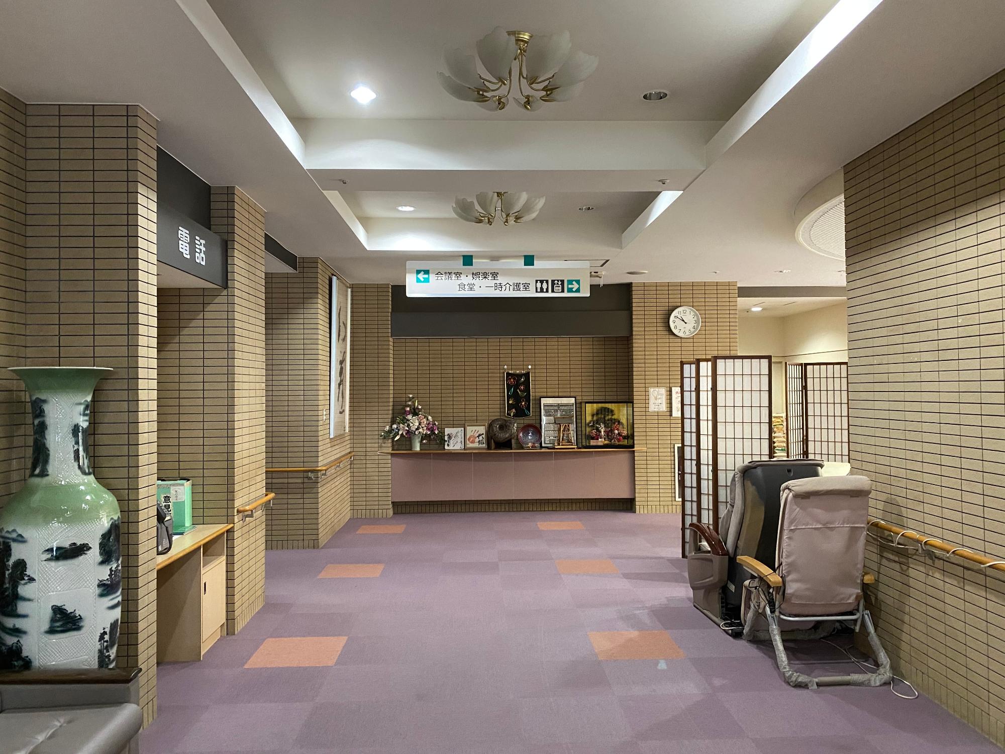 肌色のタイルと小豆色の絨毯で温かみのある雰囲気の施設内観の写真