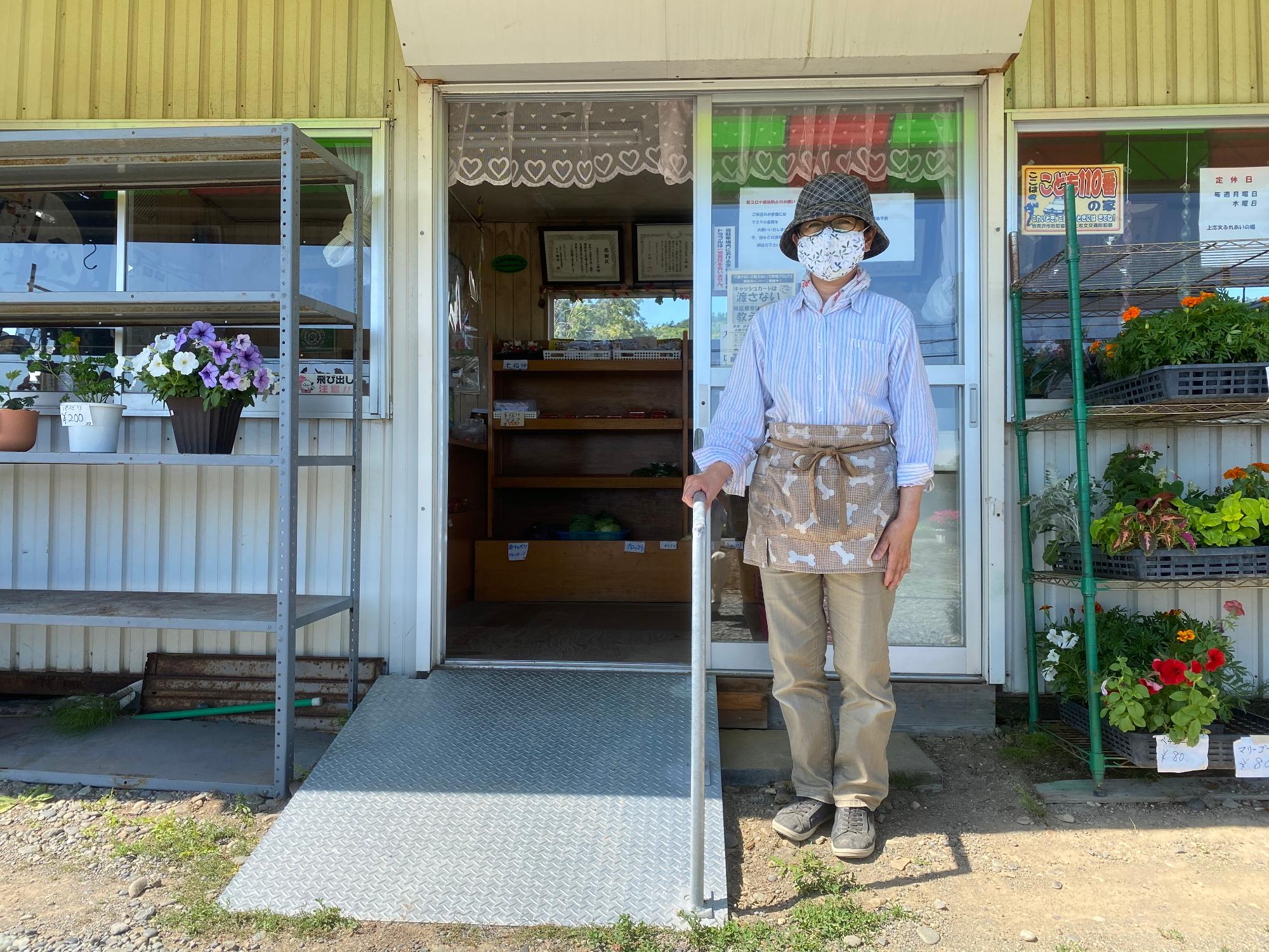 完成した新しい手すりつきスロープの横でほほ笑む事業者の写真