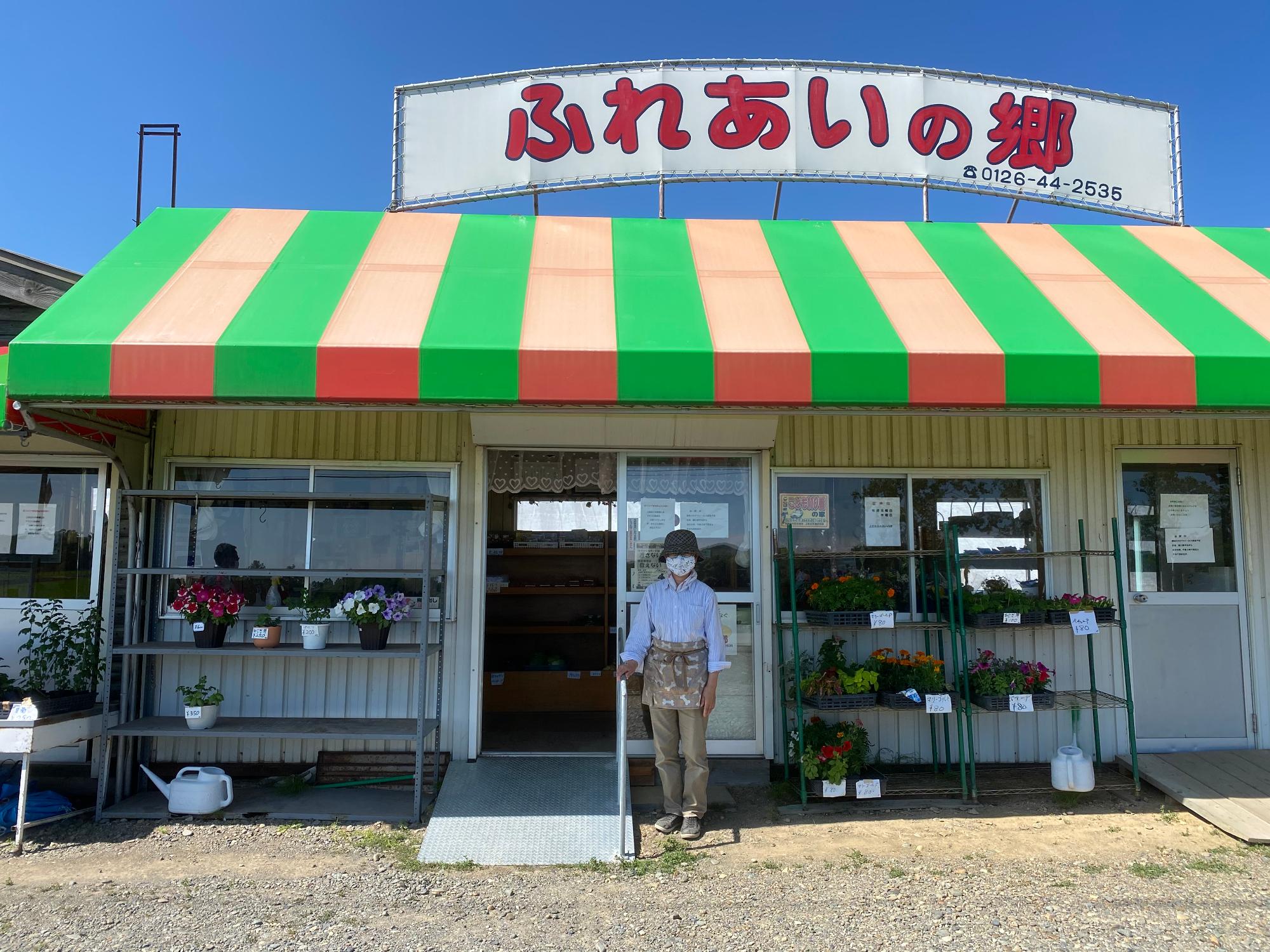 オレンジと緑の縞模様の屋根が特徴的な「上志文ふれあいの郷」店舗外観の写真