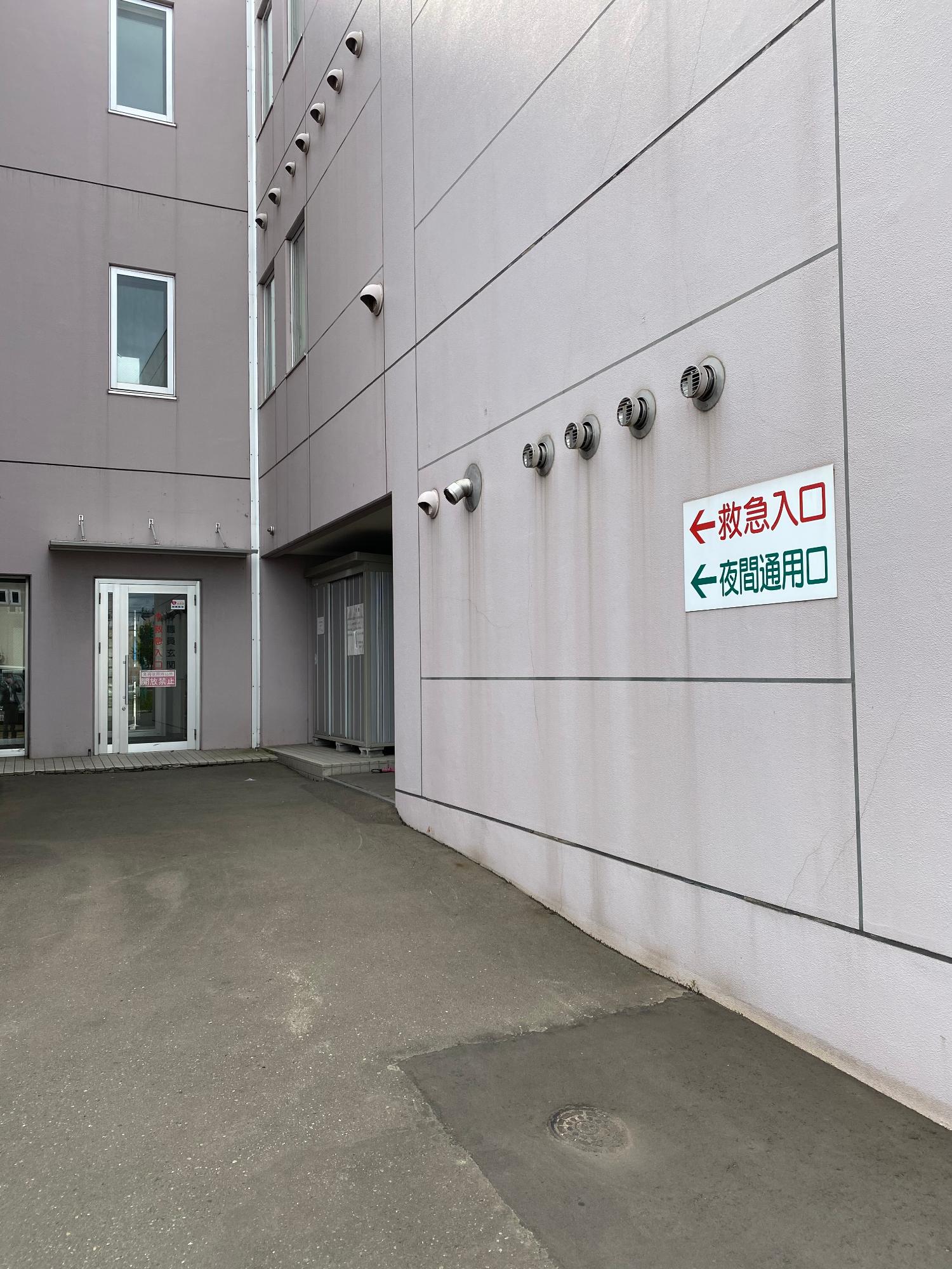 入り口手前に段差がある簡易スロープ導入以前の救急搬送口と駐車場の写真