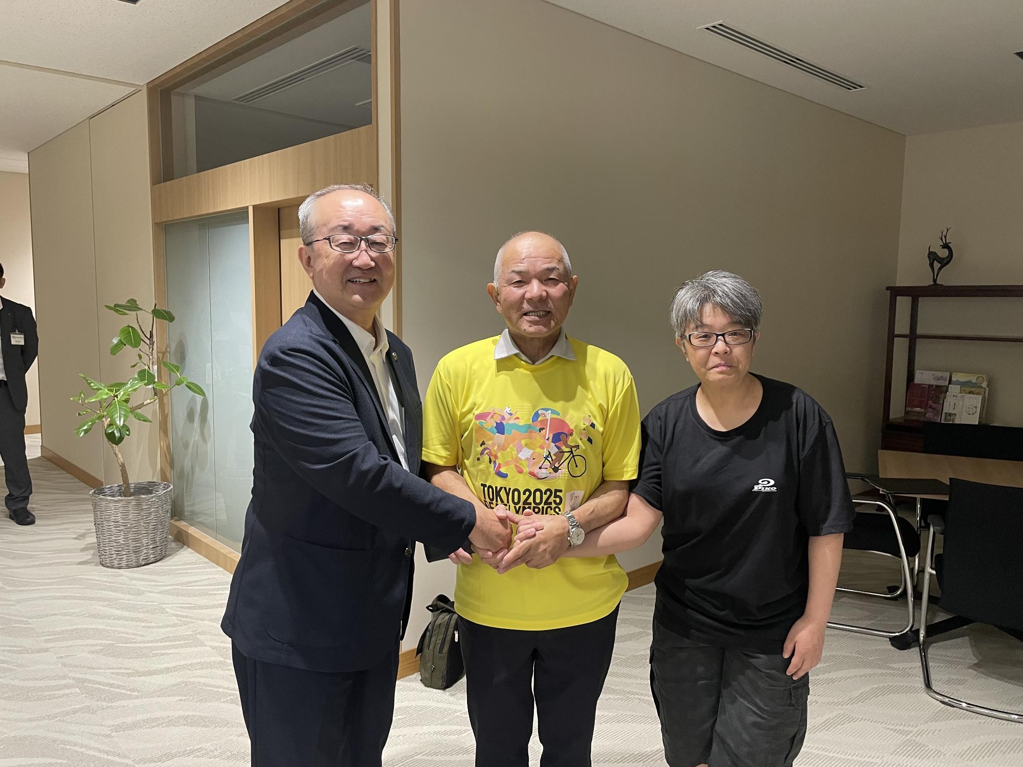 市長と北海道ろうあ連盟理事長と岩見沢ろうあ協会会長の3名で握手をする場面の画像