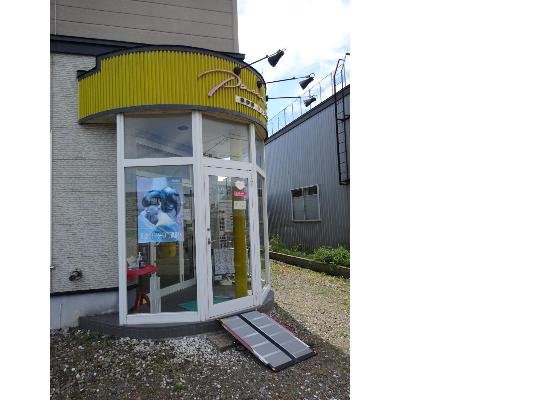 黄色い看板にガラス戸の美容室パッション入口の写真