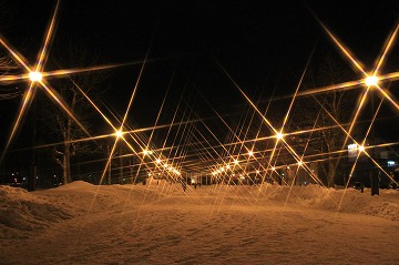 街頭が手前から奥に両側に並んでいる雪景色の写真