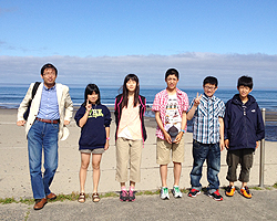 海をバックに記念撮影する国際交流員と中学生訪問団員たちの写真