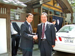 2006年5月に藩陽市からの訪問団が訪れた際、瓦屋根の建物の前で握手している様子の写真