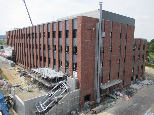 新庁舎の外観をやや上から撮影した写真。赤レンガ造りの大きな建物が見える。