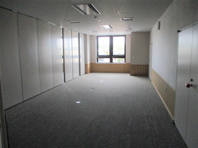 奥に窓があり、左に仕切りのような壁がある部屋の写真