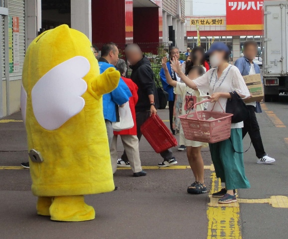 選挙のキャラクターめいすいくんに手を振っている親子の様子の写真