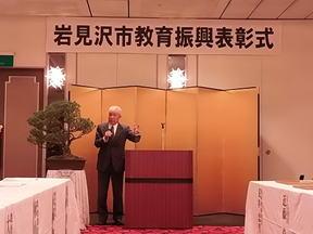 一人の男性が表彰式の挨拶をしている写真