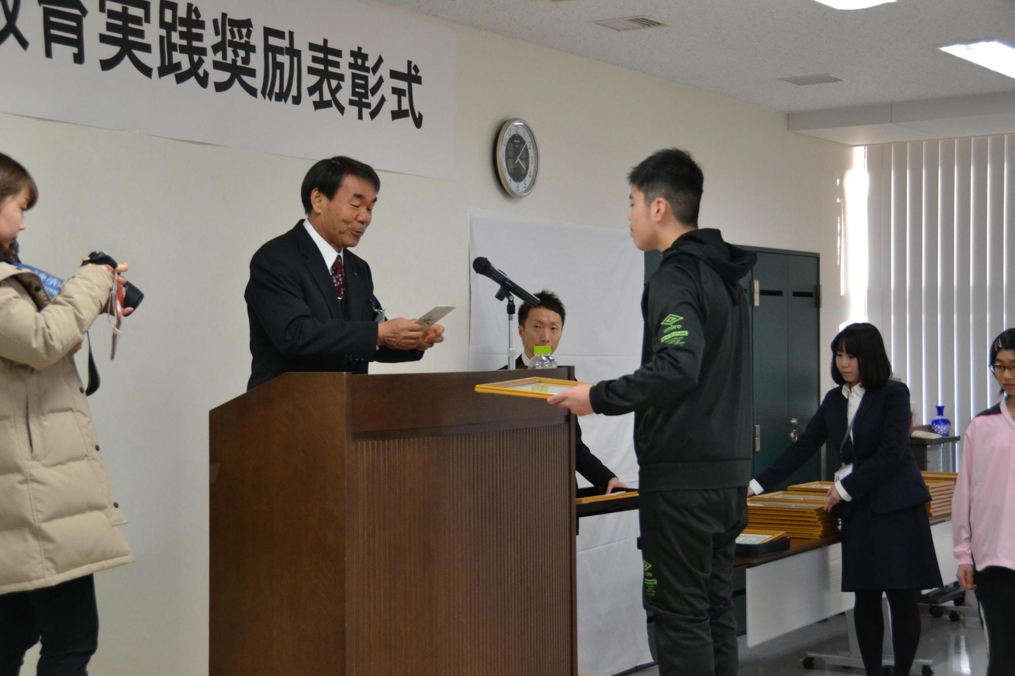 体育・文化活動等で活躍した生徒が賞状を受け取っている写真