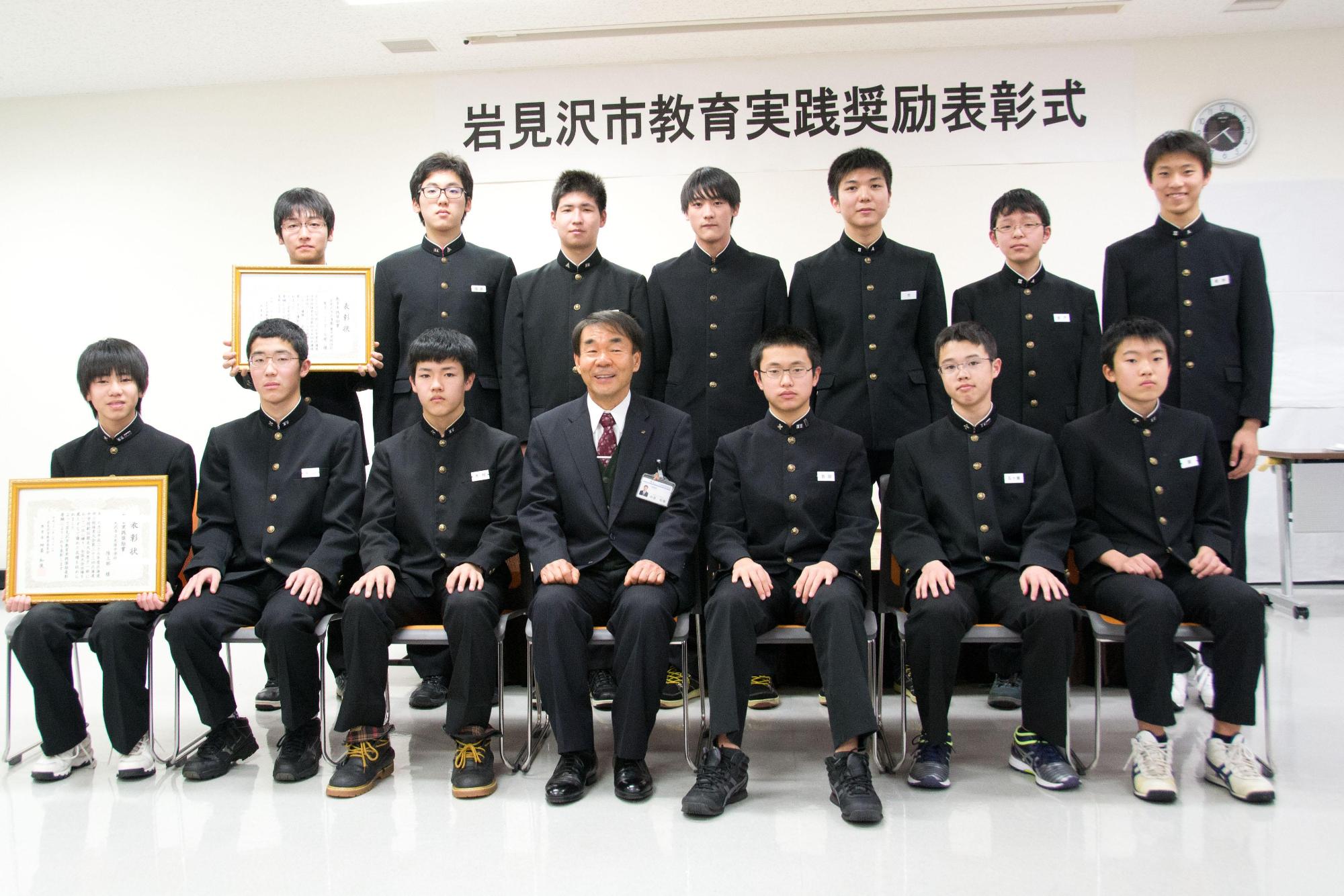 学生服を着た受賞者の皆さんで記念撮影をしている写真