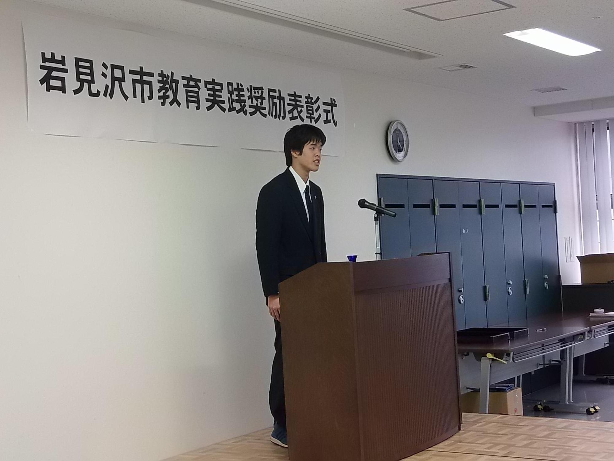 壇上で、受賞者代表挨拶をする、制服を着た住永さんの写真