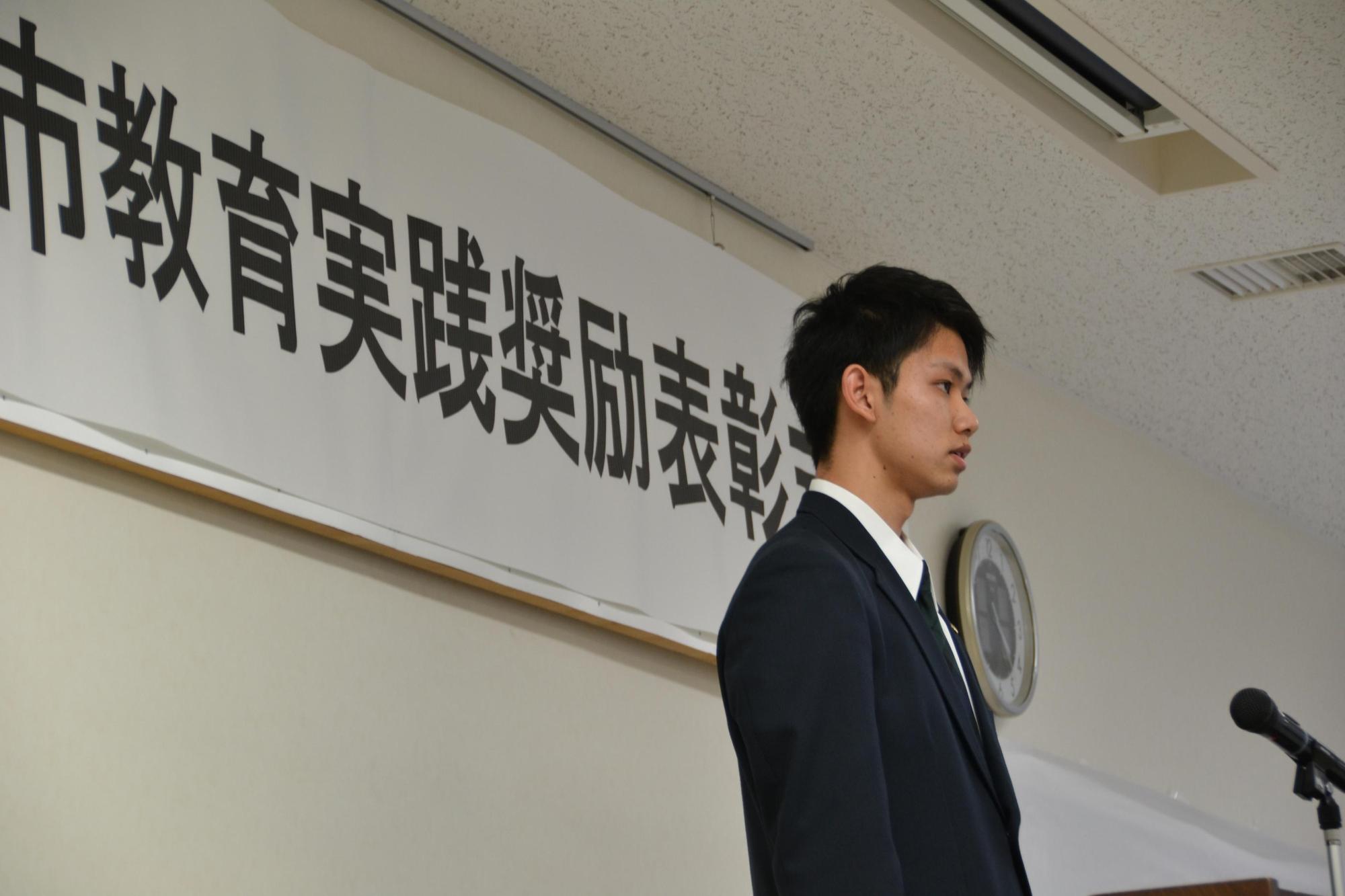 壇上で、受賞者代表挨拶をする、制服を着た笹谷さんの写真