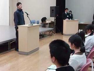 受賞者が演台に立って挨拶をしている写真