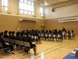 表彰式の椅子に座る数人の男女の様子の写真