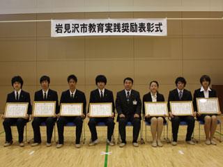 高校の個人と団体の一般の受賞者の表彰式に座る数人の男女の様子の写真