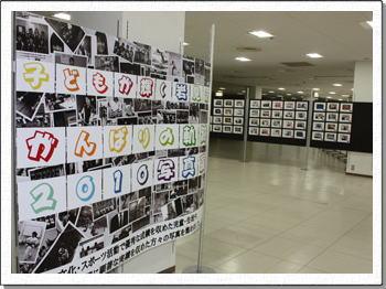 写真展のポスターと、展示されている写真がある会場の様子