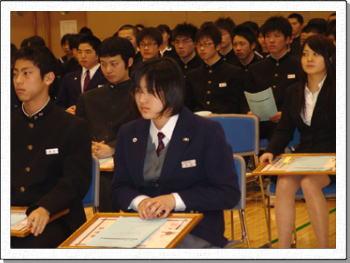ネームプレートをつけ表彰されるのを待つ学生服、ブレザーの児童生徒たちの写真