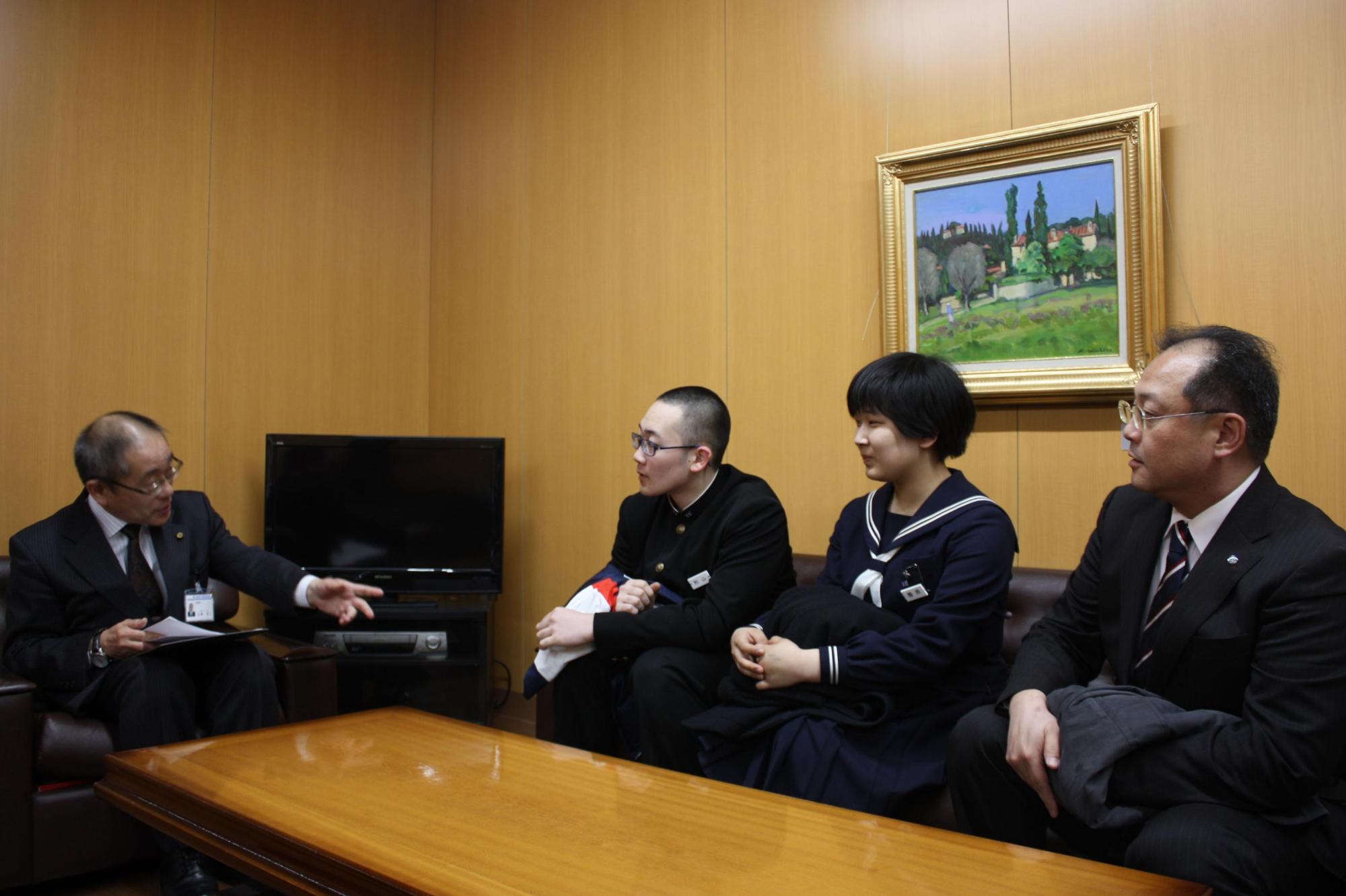 教育長と2人の制服姿の生徒と対話をする様子