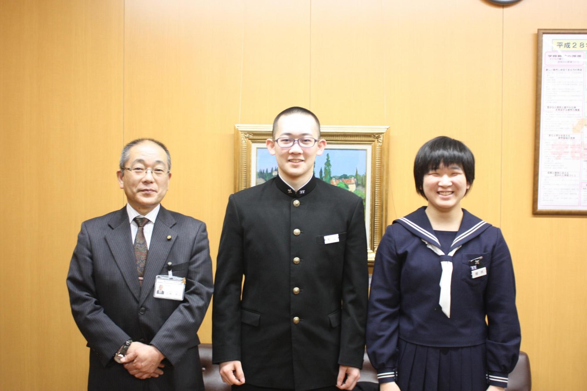 左から教育長、2人の制服姿の生徒が並んでいる笑顔の記念写真