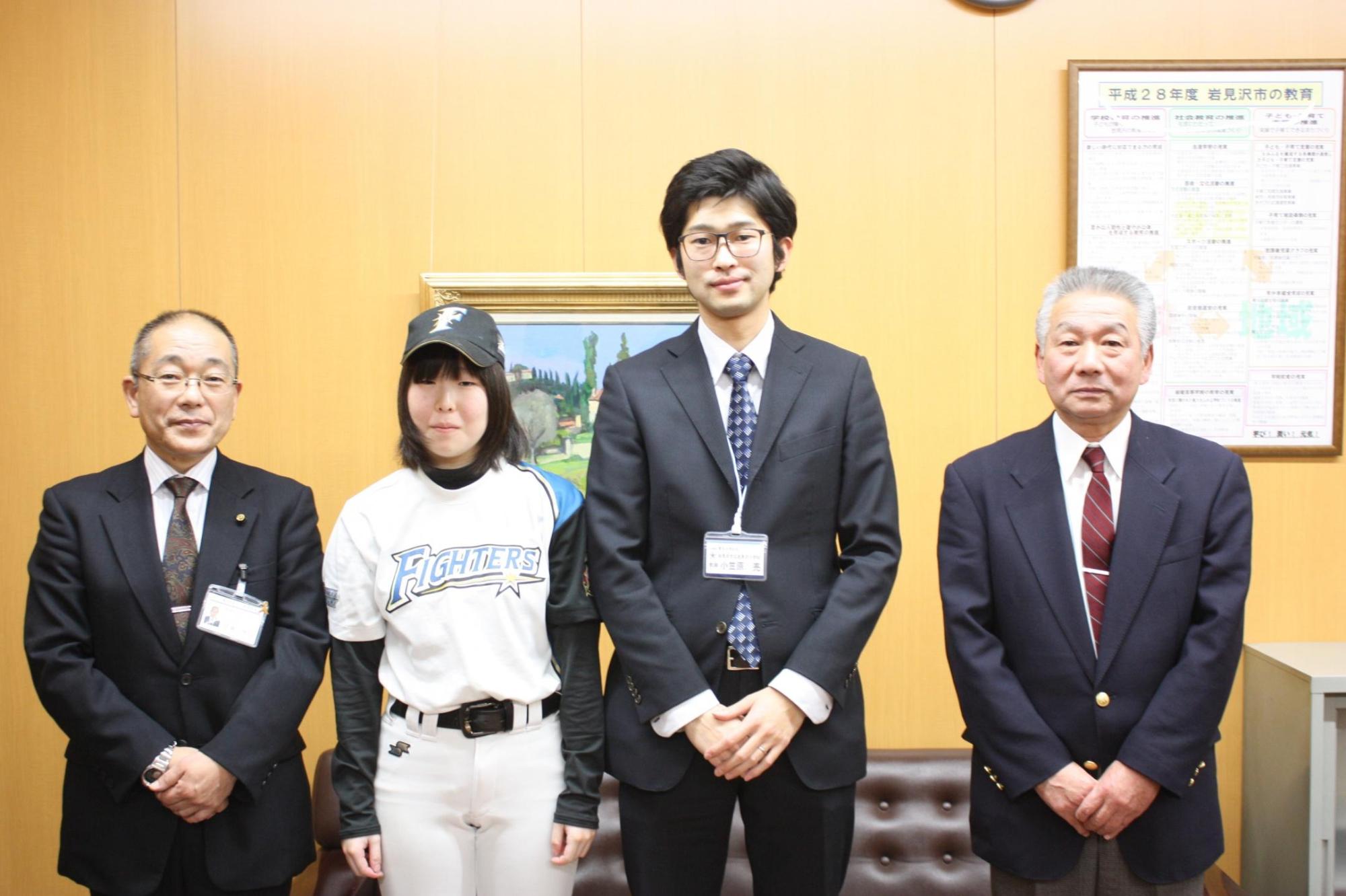 左から教育長、ユニフォーム姿の川瀬さん、2人の男性が並び立った写真