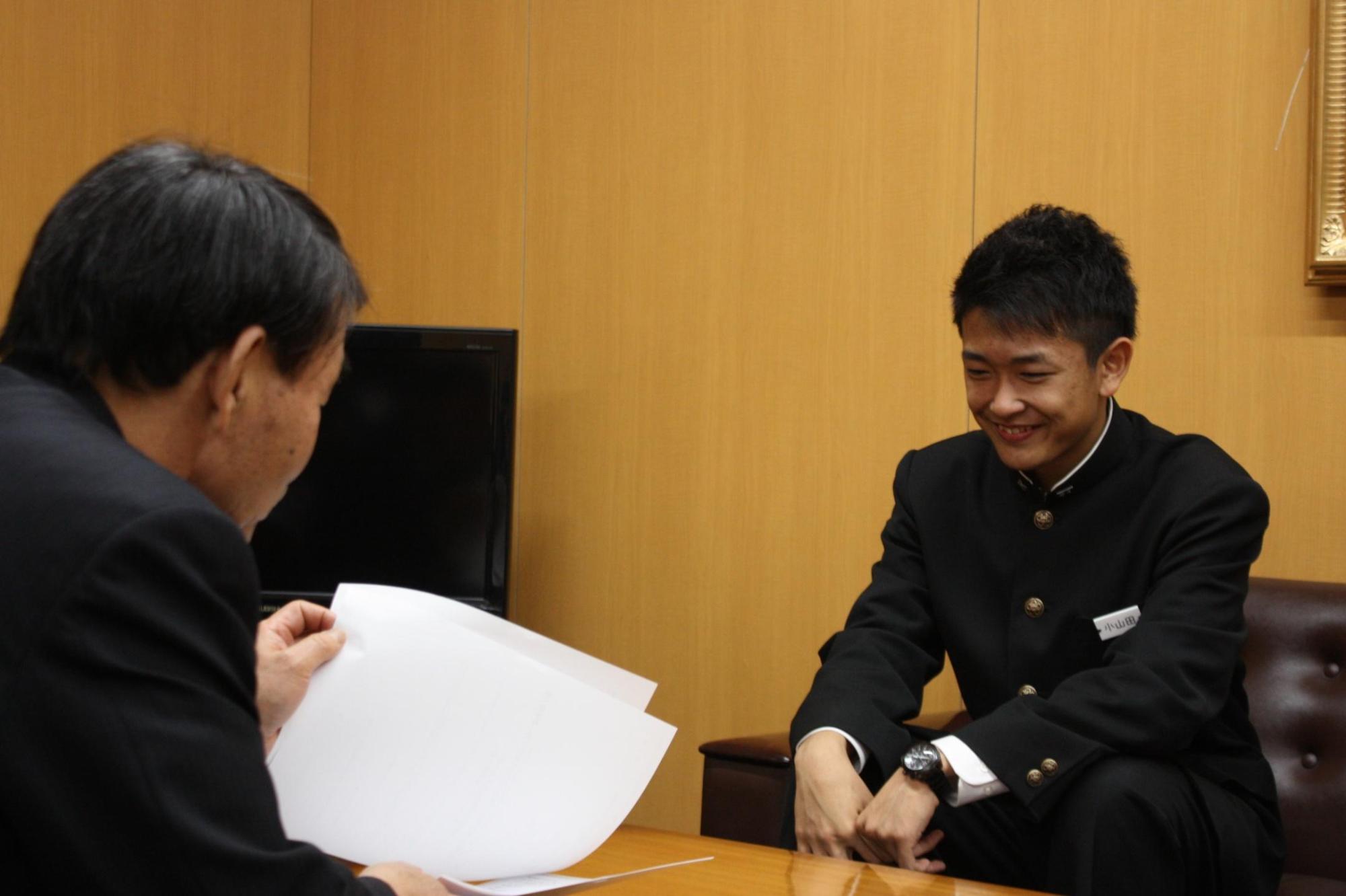 教育長と小山田さんが向かい合い資料をもって話し合う様子の写真