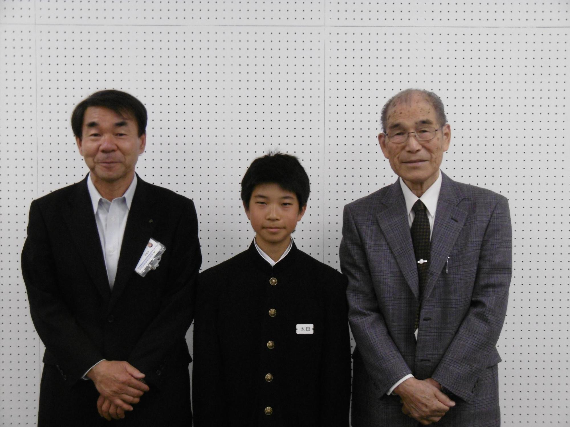 教育長と並ぶ太田さんと男性の写真