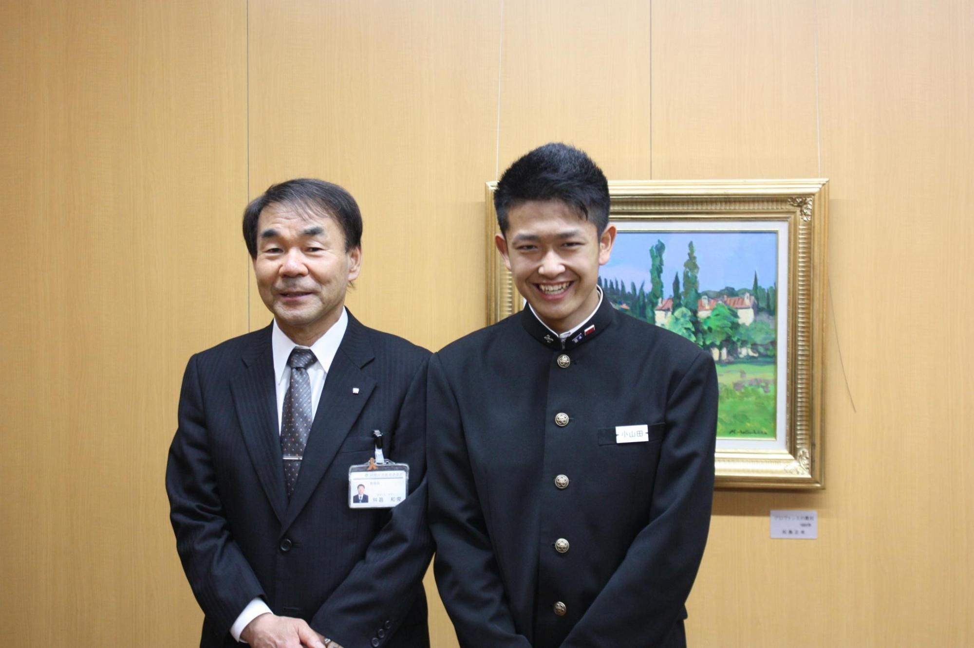 教育長と小山田凌さんと撮影した写真。二人とも正面を向いて笑顔で撮影にのぞんでいる。