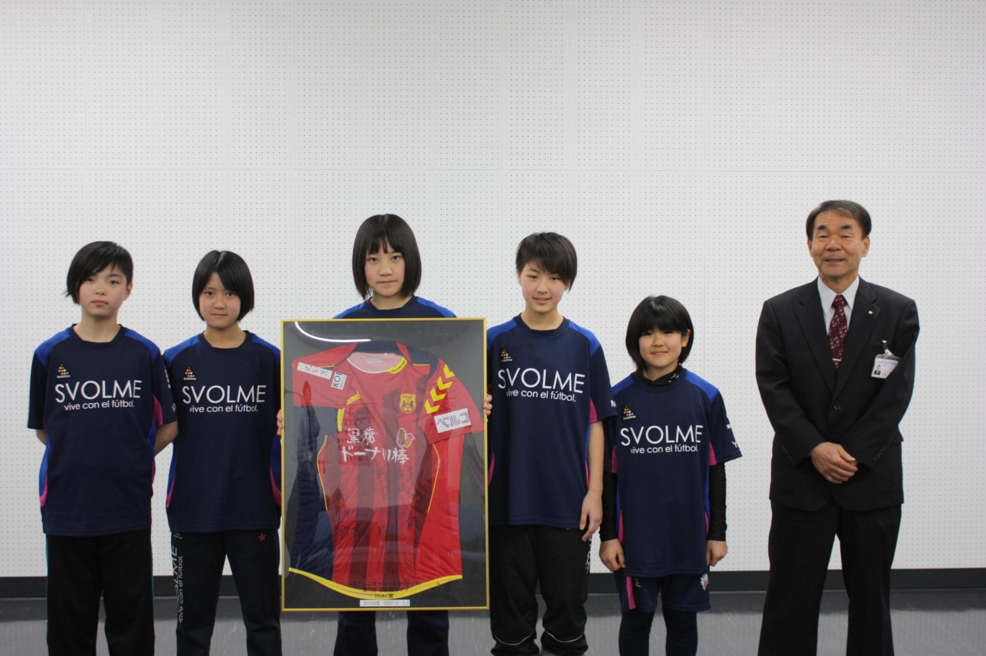 教育長とユニフォームを着た5人の子供達を撮影した写真。