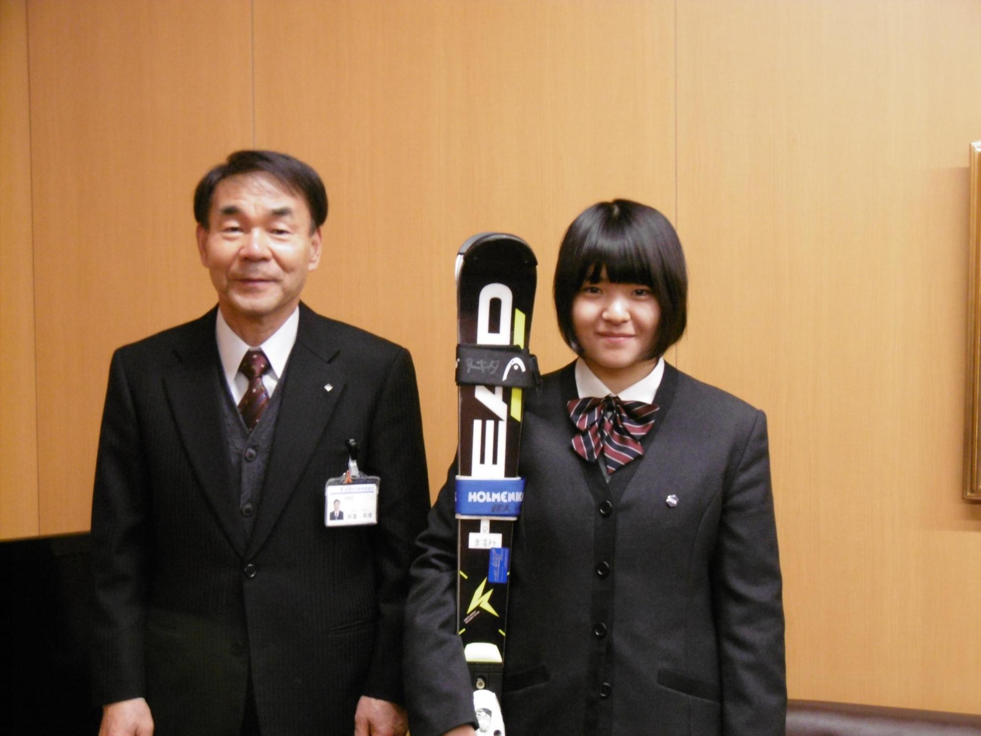 教育長とスキー板を持った女子高生が記念撮影をした写真。