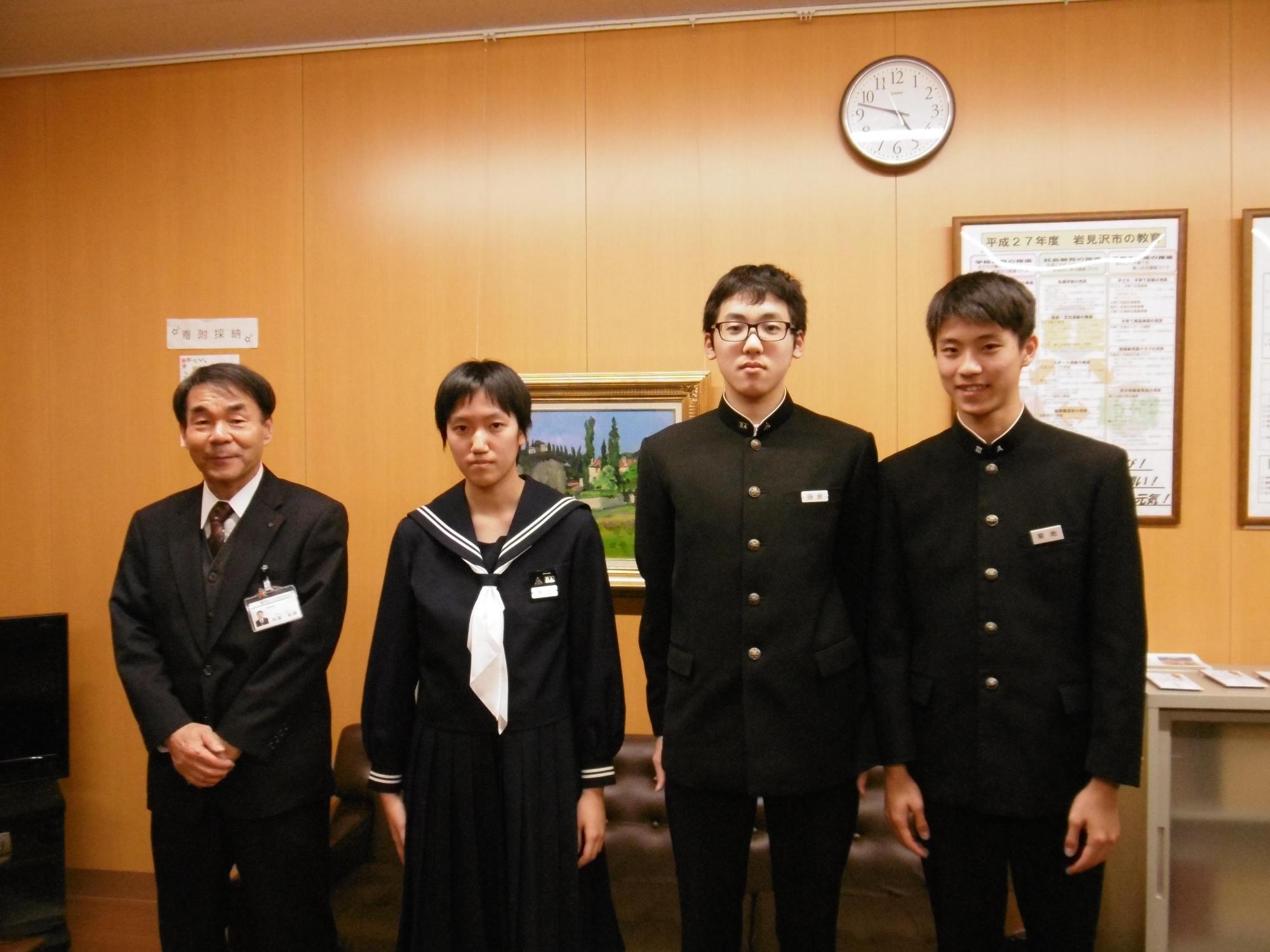 学ランを着た男子二人とセーラー服を着た女子二人と教育長が記念撮影をした写真。