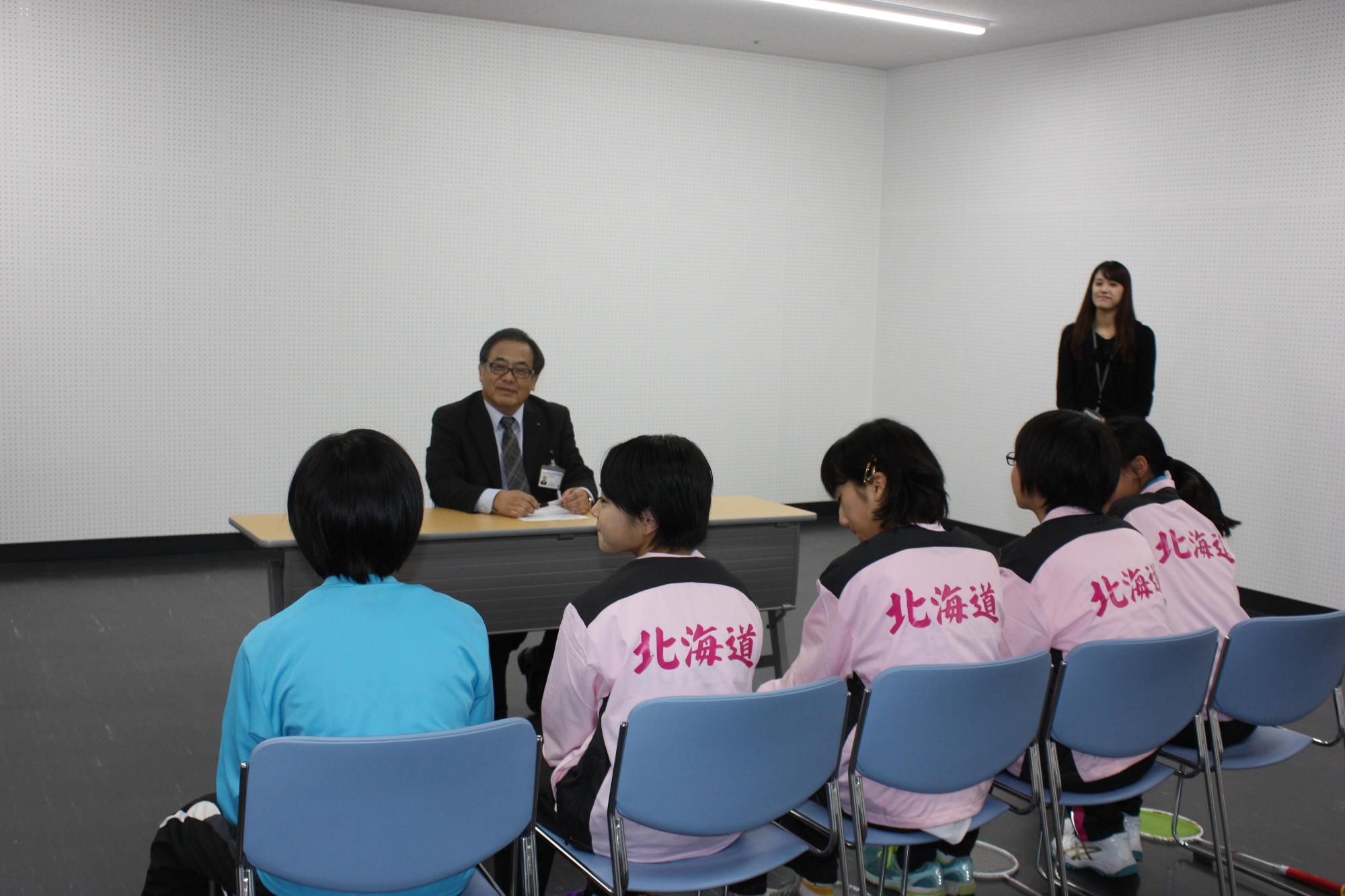 岩見沢市教育長を訪問し、談笑している様子の開発 茉子さん、渡辺 真歩さん、石岡 陽さん、桜本 和李さん、山岡 奈央さんが映っている写真
