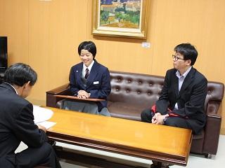 岩見沢市教育長を訪問し、ソファに座り教育長と談笑している様子の中山 璃子さんを撮影した写真