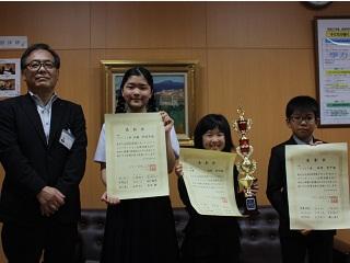 岩見沢市教育長とそれぞれ賞状を持っている田村 結羽さん、地崎 孝平さん、佐藤 那留采さんの写真