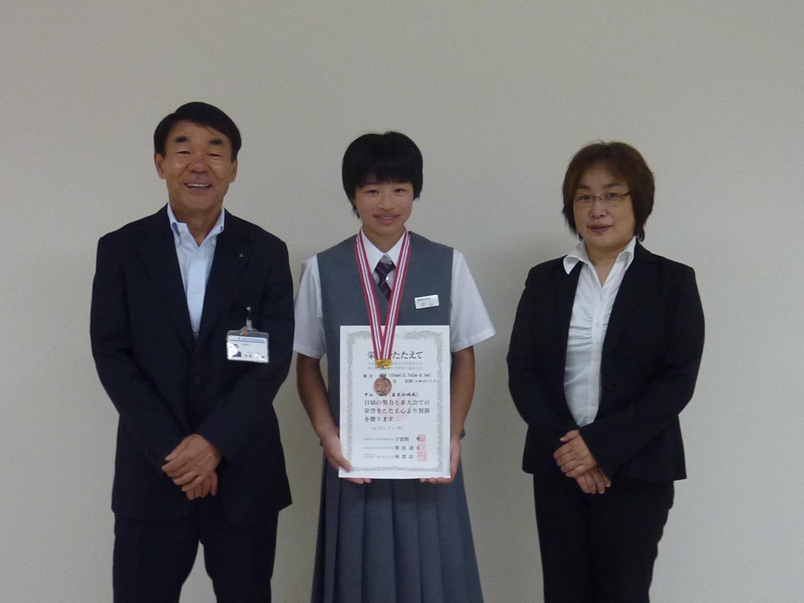 中山 璃子さん,制服を着た女の人と教育長が記念撮影をした写真。