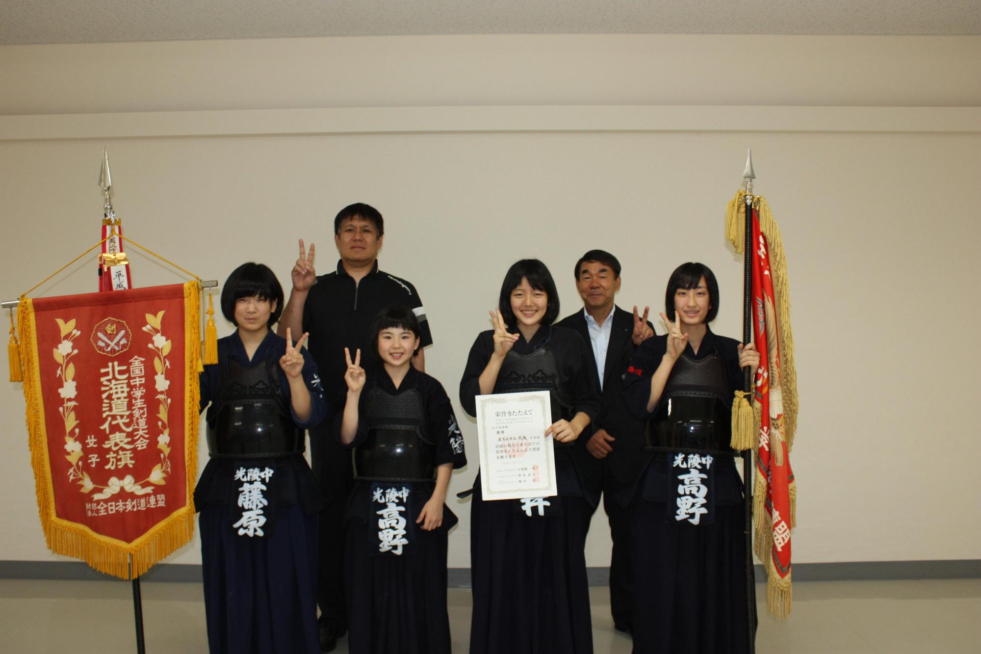 剣道着を着た中学生数人と教育長が記念撮影をした写真。