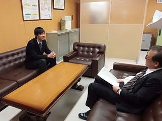 岩見沢市の教育長を訪問し、ソファに腰かけて教育長と談笑している菅野尚宏さんを撮影した写真