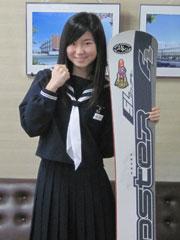 スノーボードを片手にガッツポーズをする女子学生の写真
