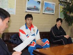 教育長の横に座っているジャージを着た学生たちの写真